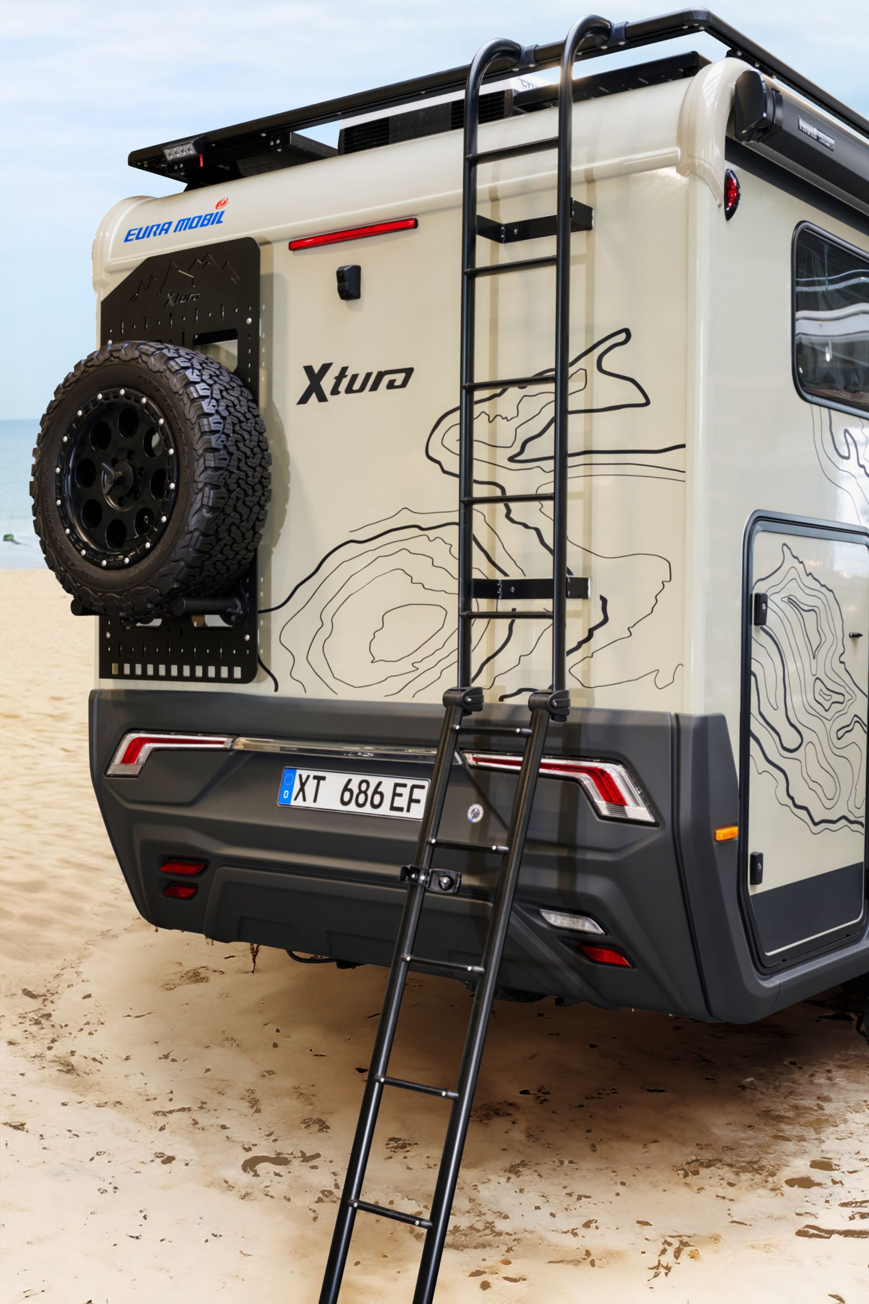 Hinteransicht des Xtura mit Ersatzrad und Leiter auf das Dach.
