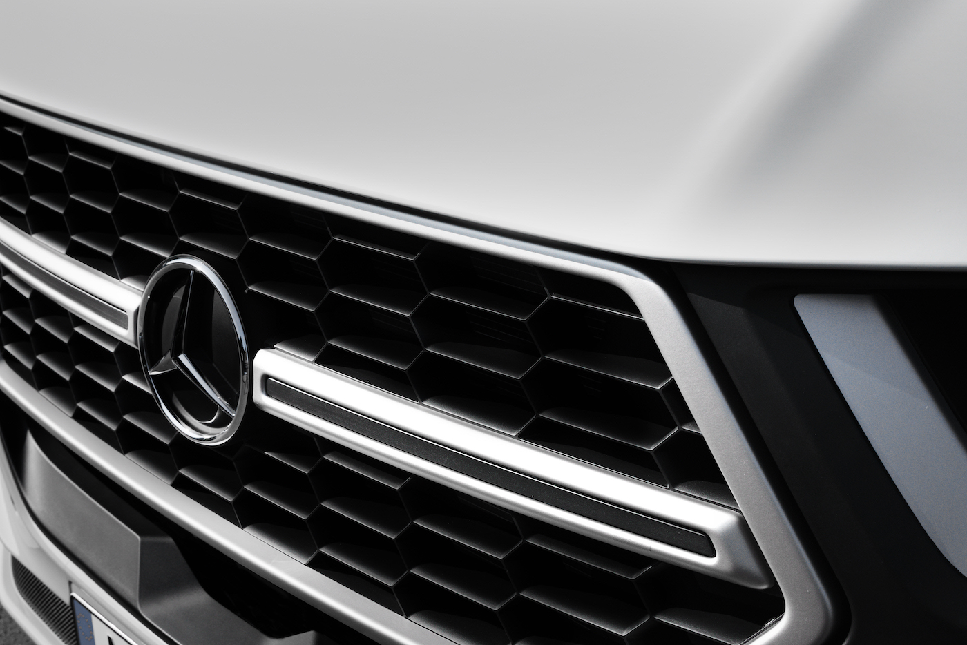 Detailansicht der Autofront mit Mercedes-Stern.