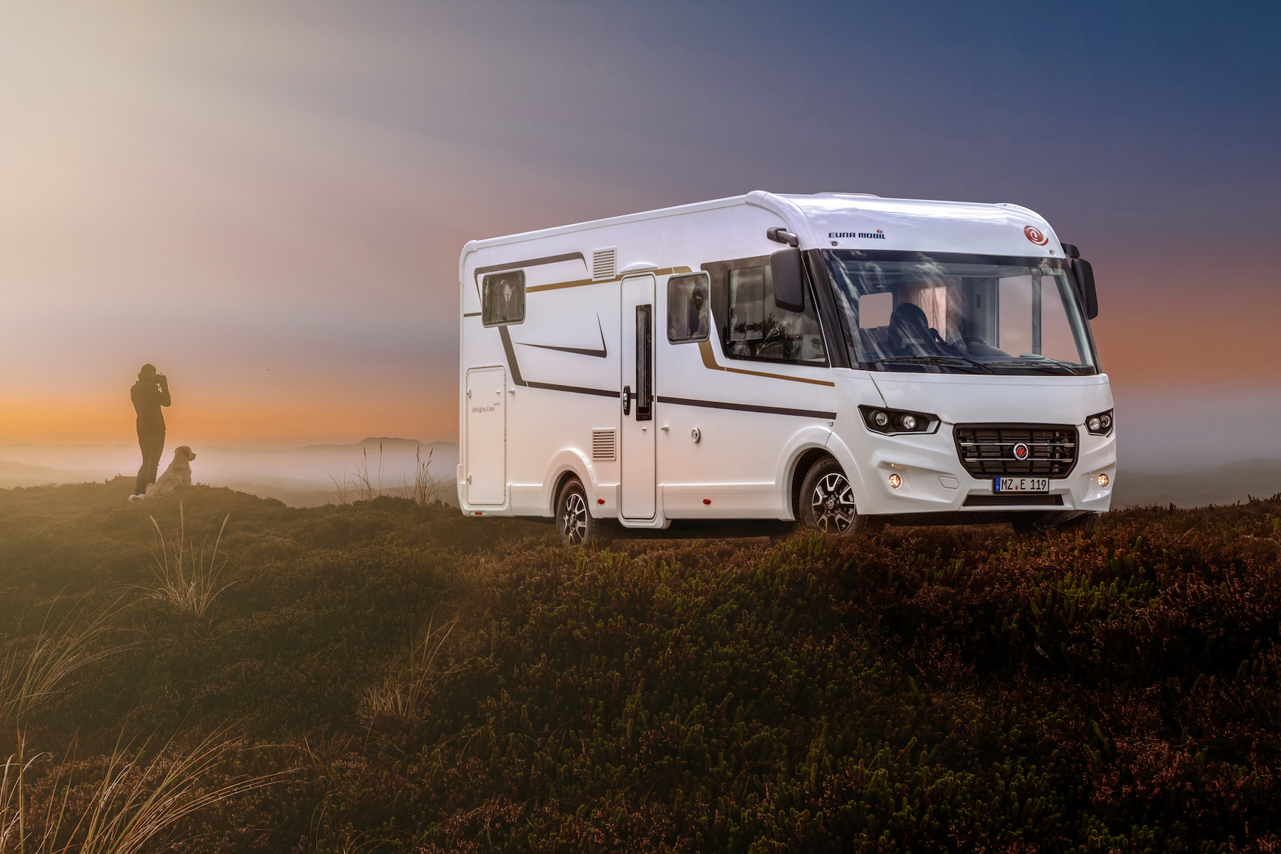 Wohnmobil vor atmosphärischem Abendhimmel.